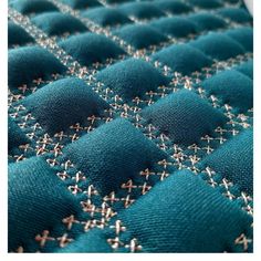 a close up view of a quilted fabric with cross stitching on the edges