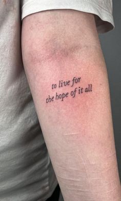 a person with a tattoo on their arm that says to live for the hope of it all