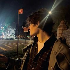 a man standing on the side of a road at night