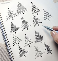 someone is drawing christmas trees on paper with a pen and inking them into their notebooks