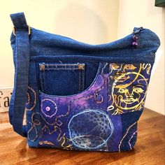 a purse made out of blue jeans on top of a wooden table