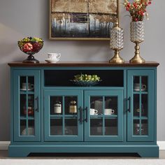 a blue cabinet with glass doors and two vases on top