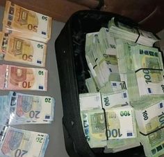 a suitcase filled with lots of money sitting on top of a table