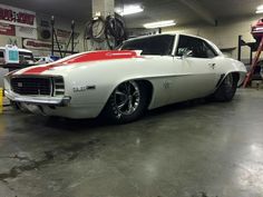 a white and red car parked in a garage