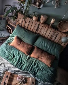 a bed with pillows and blankets on top of it, next to a wooden headboard