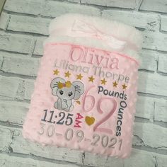 a pink baby blanket with a koala on it hanging from the side of a brick wall