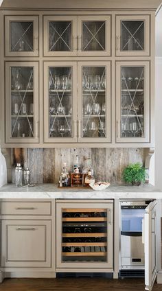 a kitchen with cabinets and wine glasses on the counter