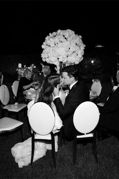 black and white photograph of bride and groom kissing at their wedding reception in the evening