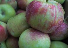 a pile of green and red apples sitting on top of each other