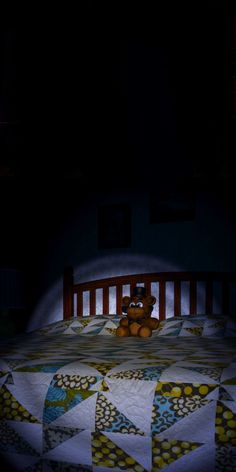 a teddy bear sitting on top of a bed in the dark