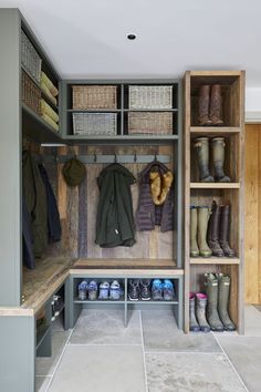 a walk in closet filled with lots of boots and coats on shelves next to shoes