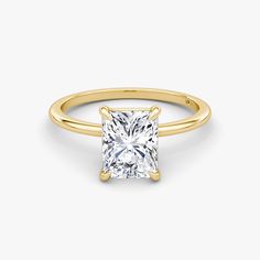 a yellow gold ring with a princess cut diamond