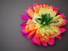 a multicolored paper flower on a gray background