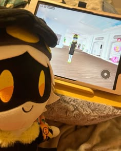 a stuffed animal is sitting in front of a computer screen with an animated character on it