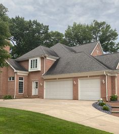 a large brick house with two garages on each side