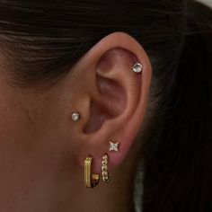 a close up of a person's ear with three different types of piercings