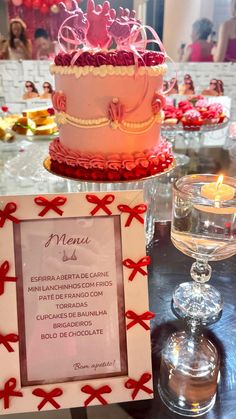 a table topped with a pink cake covered in frosting