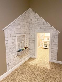 a doll house made out of white bricks with a window and flower box in the doorway