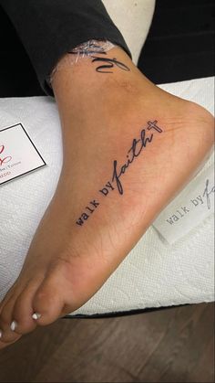 a woman's foot with the words walk by faith written on her left side