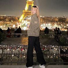 a woman standing in front of the eiffel tower