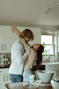 a man and woman standing in a kitchen together