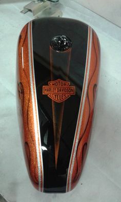 an orange and black motorcycle engine cover on the back of a motorcycle with chrome trim