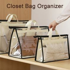 three clear bags with black handles are sitting on a wooden shelf and one is holding a white bag