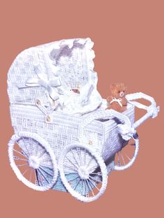 a white wicker baby carriage with a teddy bear in the front and side wheels