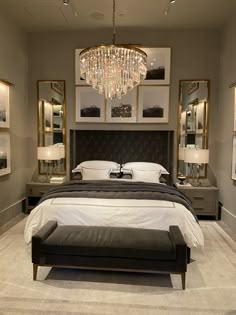 a large bed sitting in a bedroom under a chandelier