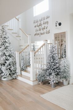 white christmas trees are lined up on the stairs