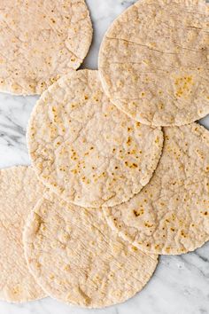 tortillas stacked on top of each other on a white marble counter with yellow speckles