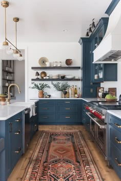 60+ Vibrant Kitchens With Blue Cabinets Blue Kitchen Cabinets Copper Hardware, Lower Blue Kitchen Cabinets, Blue Kitchen With Gold Hardware, Deep Blue Kitchen Cabinets, Indigo Kitchen Cabinets, Blue Cupboards Kitchen, Blue Cabinet Kitchen, Blue And Gold Kitchen, Blue Cabinets Kitchen