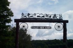 a wooden sign that says valley new faces with animals on it and hanging from the top