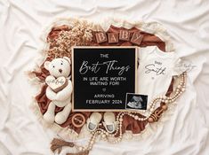 a baby announcement with teddy bears and other items on a white bed sheet that says, the best things in life are worth