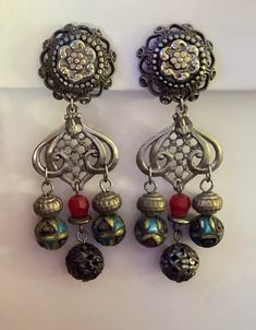 "Gorgeous eye-catching vintage Ann Cichon boho dangle earrings.    The earrings are 3 3/4\" long and 1 1/8\" wide at widest point. One is marked Ann Cichon Dallas.  The item(s) may need a good cleaning. I do not clean items, leaving that to the discretion of the buyer.  Please ask any questions before purchase as there are no returns/refunds. I am not an expert on vintage jewelry. This is from an estate. I am researching as I go.  Only ships to the lower 48 United States, excludes Hawaii and Alaska. Thank you for looking and have a great day." Red Bohemian Chandelier Earrings Nickel-free, Red Bohemian Nickel-free Chandelier Earrings, Vintage Festival Earrings With Dangling Beads, Bohemian Red Nickel-free Chandelier Earrings, Vintage Dangle Chandelier Earrings For Festivals, Handmade Bohemian Dangle Clip-on Earrings, Bohemian Metal Chandelier Earrings For Festivals, Vintage Nickel-free Earrings For Festival, Nickel-free Vintage Earrings For Festival