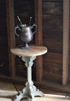 a silver vase sitting on top of a wooden table