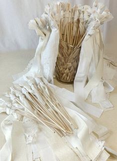 a vase filled with lots of white ribbons