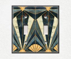 an art deco light switch plate cover in blue and gold with two lights on each side