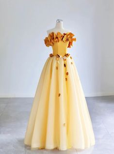 Ornate and breathtaking, this yellow prom dress is designed for those who love to make a statement. The off-the-shoulder bodice is embellished with large, handcrafted floral appliques, adding a unique and romantic touch to the design. The corset-style top cinches at the waist, providing a flattering and secure fit, while the full, tulle skirt creates a dramatic and elegant silhouette. Each layer of the skirt is delicately gathered, ensuring a graceful flow with every movement. Perfect for proms, balls, or any formal event, this dress promises to make you the center of attention. The attention to detail and high-quality materials ensure both beauty and comfort, allowing you to move with ease and confidence. Wear this gown and let its enchanting design transform your special night into an un Prom Dress Off The Shoulder, Princess Academy, Prom Dresses Off The Shoulder, Tulle Applique, Yule Ball, Prom Dresses Yellow, Prom Dresses Gowns, Formal Evening Dress, Princess Dresses