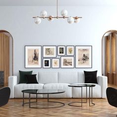 a living room filled with white furniture and pictures on the wall above it's coffee table