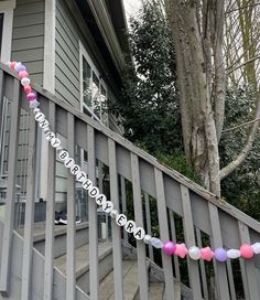 there is a sign that says happy birthday on the front porch with balloons and streamers