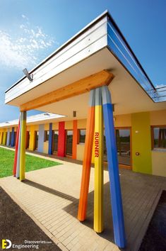 an outside view of a multi - colored building with colorful columns in the foreground