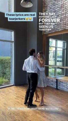 a man and woman dancing together in an empty room with windows on the wall behind them