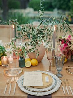 the table is set with plates, silverware, and lemons for an elegant dinner