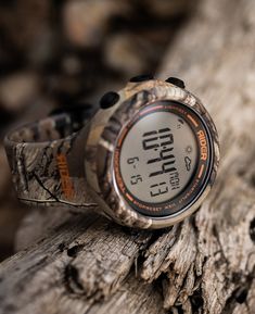 a watch sitting on top of a tree trunk