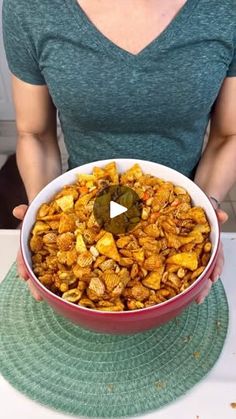 a woman holding a bowl full of food