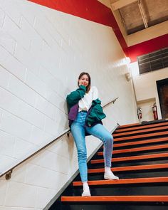 a woman leaning against the wall on some stairs