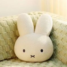 a white stuffed rabbit sitting on top of a couch