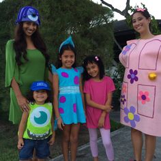 three women and two children are dressed up in costumes for the same time as they stand on a sidewalk