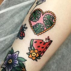 a woman's arm with tattoos on it and flowers in the shape of hearts